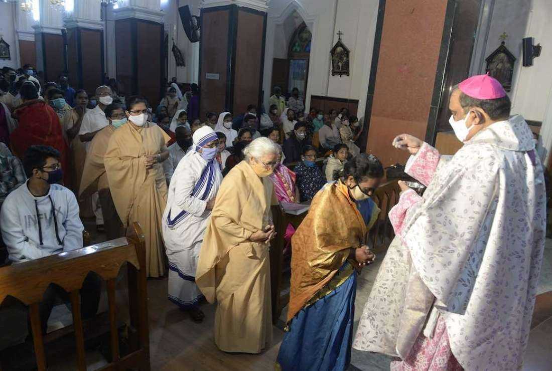 Archbishop of Hyderabad Poola Anthony (R) sprinkle ash on the head of Catholic Christians due to the Covid-19 coronavirus pandemic during an Ash Wednesday service at Saint Mary's Basilica in Secunderabad on Feb 17, 2021