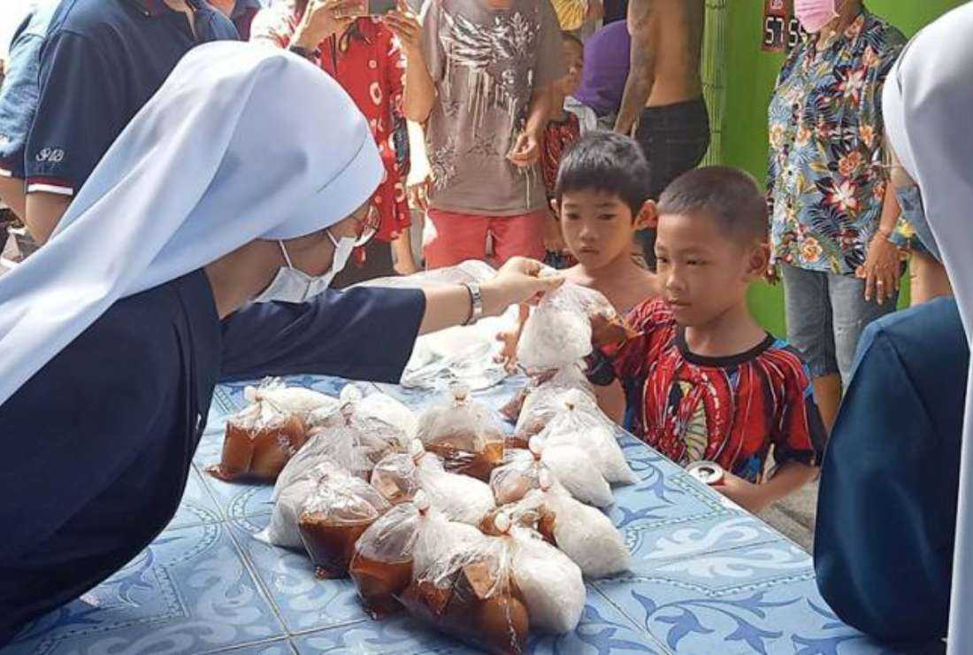 Sacred Heart of Jesus nuns distribute meals to poor children at the slum in Khlong Toei in Thai capital Bangkok
