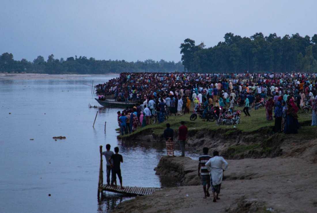 People gather as rescuers pull bodies after a boat packed with Hindu devotees sank in northern Bangladesh, leaving at least 33 dead