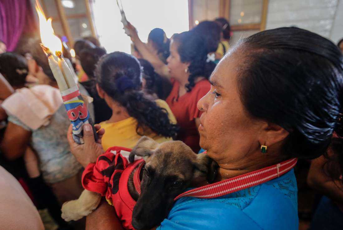 A woman brings her fancy-dressed dog to the church during the Saint Lazarus festival, at the Santa Maria Magdalena parish in Masaya, 30 km south of Managua, Nicaragua on March 13, 2016