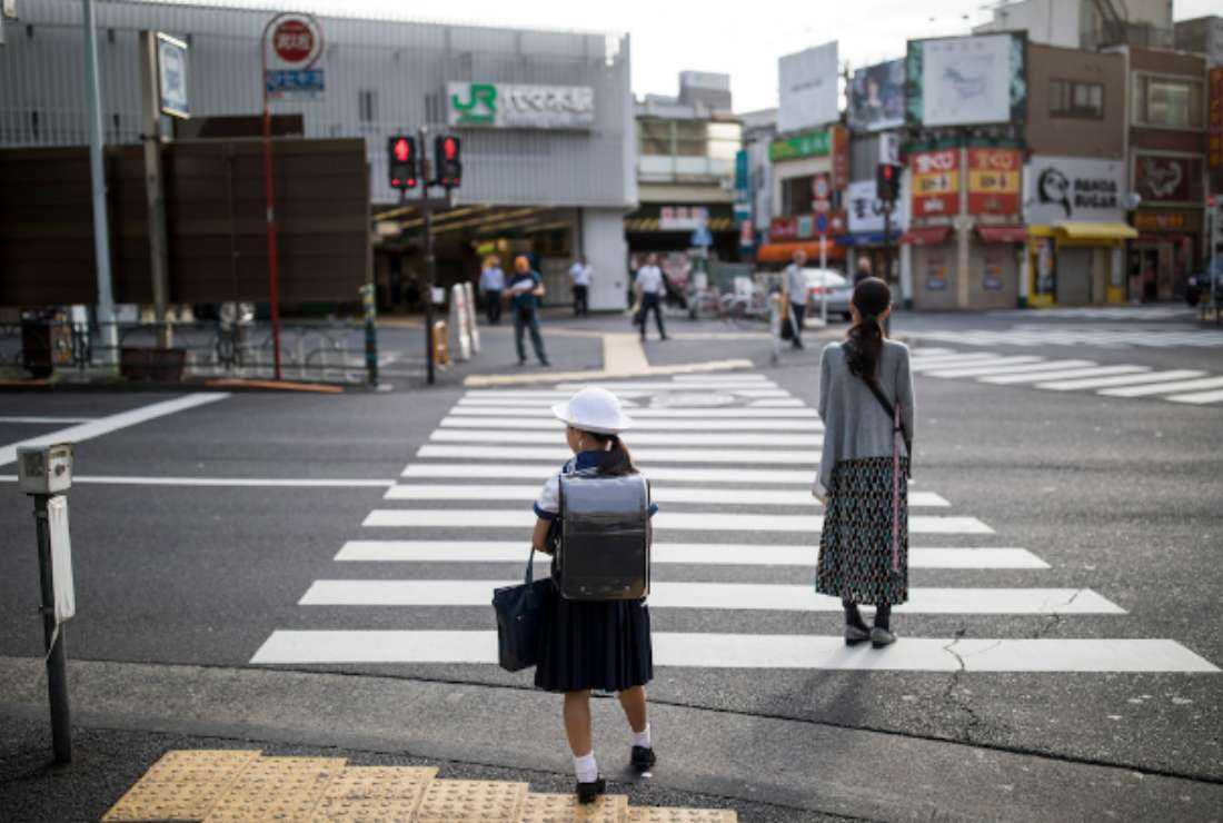 A Japanese schoolgirl waits to cross a Tokyo road. The country’s younger generations will struggle to pay the costs of a society where nearly a third of the population are aged 65 or over amid a gradual fall in birth rates