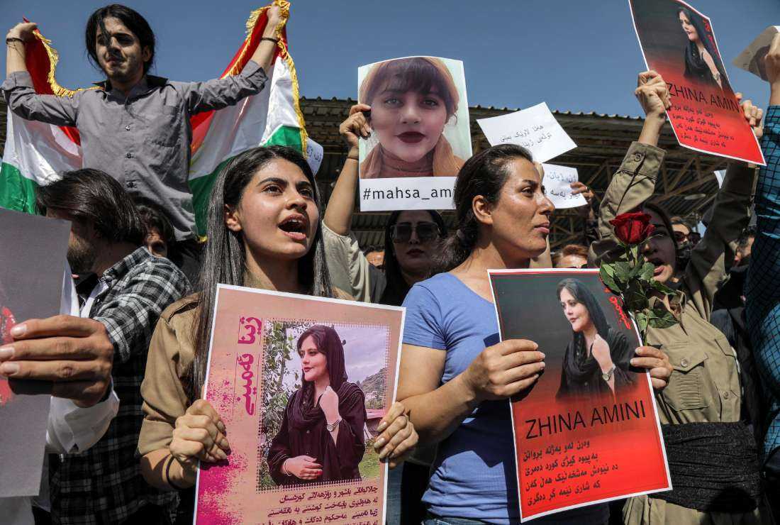 Women chant slogans and hold up signs depicting the image of 22-year-old Mahsa Amini, who died while in the custody of Iranian authorities, during a demonstration denouncing her death by Iraqi and Iranian Kurds outside the UN offices in Arbil, the capital of Iraq's autonomous Kurdistan region