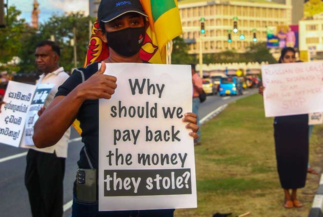 Protestors hold placards as they take part in an anti-government demonstration in Colombo on Sept. 25