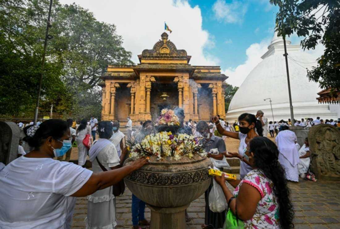 Buddhist devotees offer prayers during Poya a religious festival to mark the full moon, at Kelaniya Temple in Colombo on Sept. 10