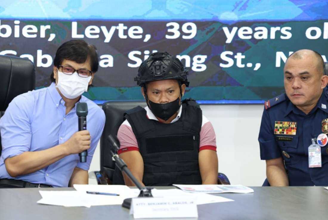 Joel Estorial (center), the alleged gunman in the killing of Philippine journalist Percival Mabasa, is presented to the media as Philippine Interior Secretary Benjamin Abalos (left) speaks during a press conference at the national police headquarters in Manila on Oct. 18