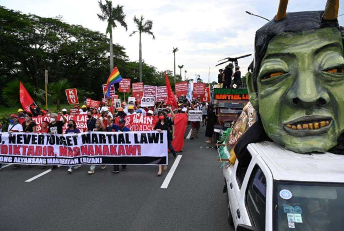 Protesters carrying placards march past an effigy of President Ferdinand Marcos Jr., during a rally to commemorate 50 years anniversary of the imposition of martial law at the university grounds in Quezon City, suburban Manila on Sept. 21