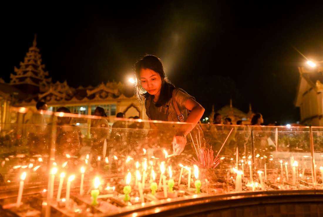 A girl lights candles at Botahtaung Pagoda during the celebrations to mark the Thadingyut festival in Yangon on Oct 9