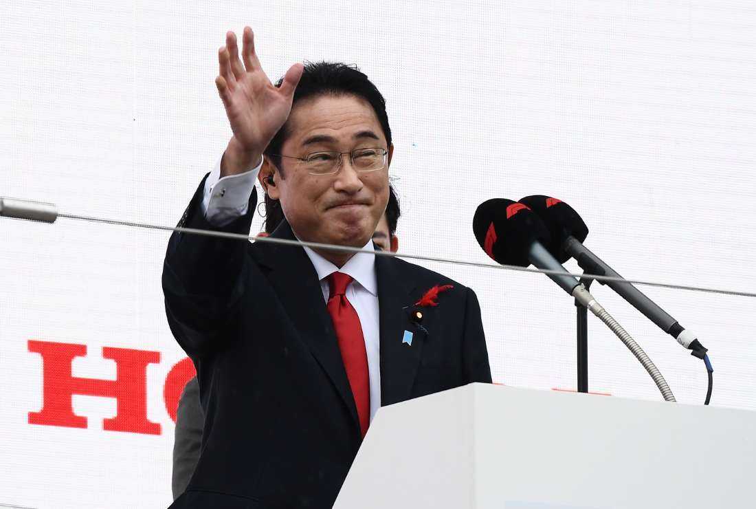 Japan's Prime Minister Fumio Kishida waves as he delivers a speech before the start of the Formula One Japanese Grand Prix at Suzuka, Mie prefecture on Oct. 9