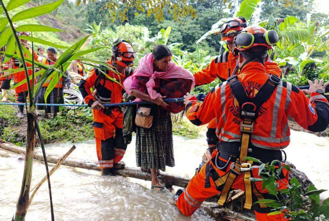 10月10日，危地马拉San Cristobal Verapaz的Queja村，在热带风暴茱莉亚经过后，志愿消防员的救援巡逻正在疏散被困在山体滑坡中的人们