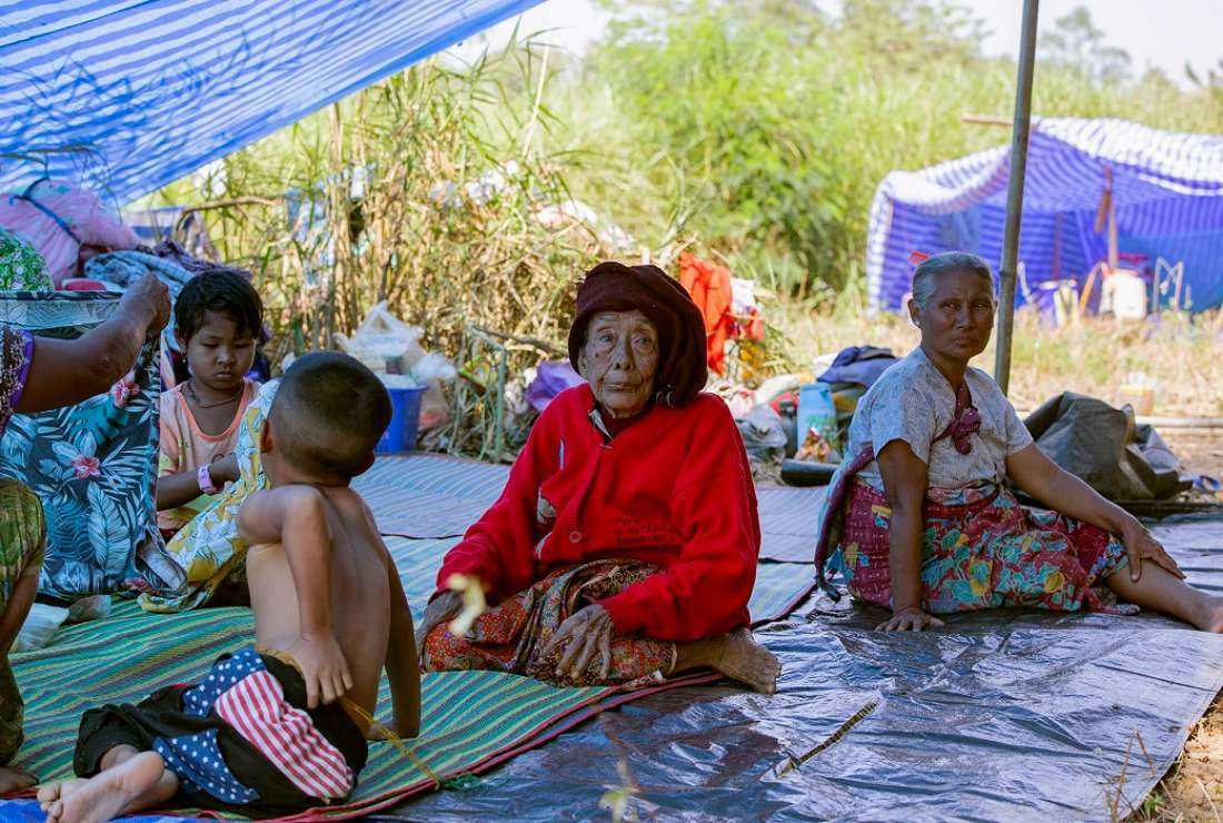 This photo taken on Jan 15, 2022 shows Myanmar refugees, who fled a surge in violence as the military cracks down on rebel groups, rest after crossing a river on the border in Thailand's Mae Sot district