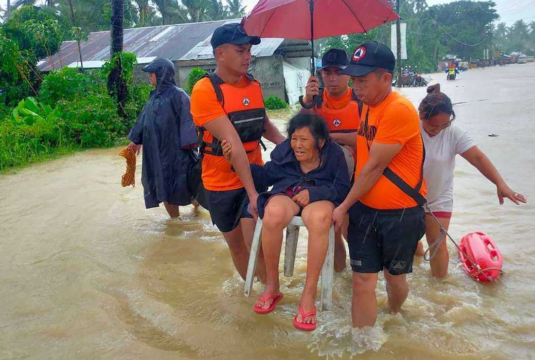 Filipino rescue workers evacuating people from a flooded area due to heavy rain brought by Tropical Storm Nalgae in Hilongos, Leyte province, on Oct. 28