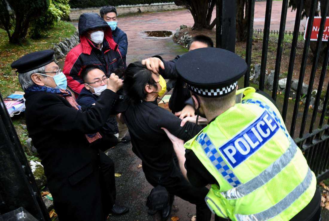 This handout from The Chaser News taken on Oct. 16 shows a scuffle between a Hong Kong pro-democracy protester (center) and Chinese consulate staff, as a British police officer attempts to intervene, during a demonstration outside the consulate in Manchester, UK