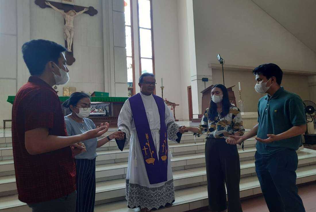 Father Aloysius Budi Purnomo, chairman of the Commission for Justice, Peace and Integrity of Creation of Semarang Episcopal Vicariate, prays with the wife and children of Paulus Iwan Budi Prasetijo at St. Ignatius Loyola Church Banjardowo, Semarang on Nov. 3