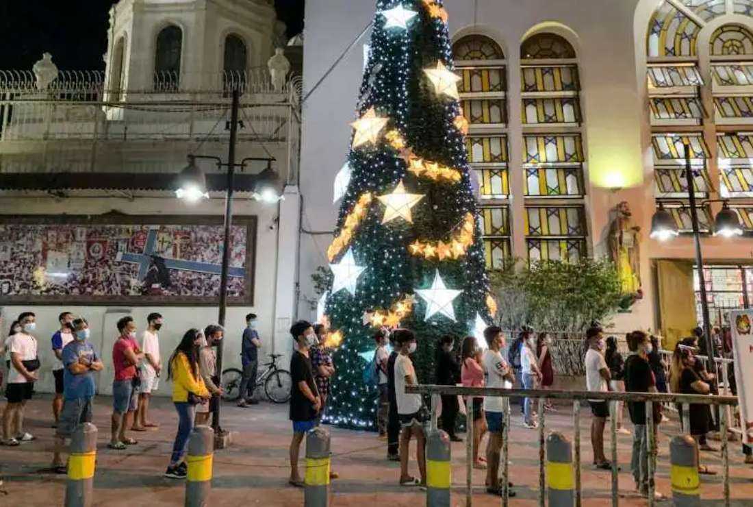 Catholic devotees attend a Christmas Eve Mass maintaining social distancing to prevent the spread of the coronavirus outside Quiapo Church in Manila on Dec. 24, 2020