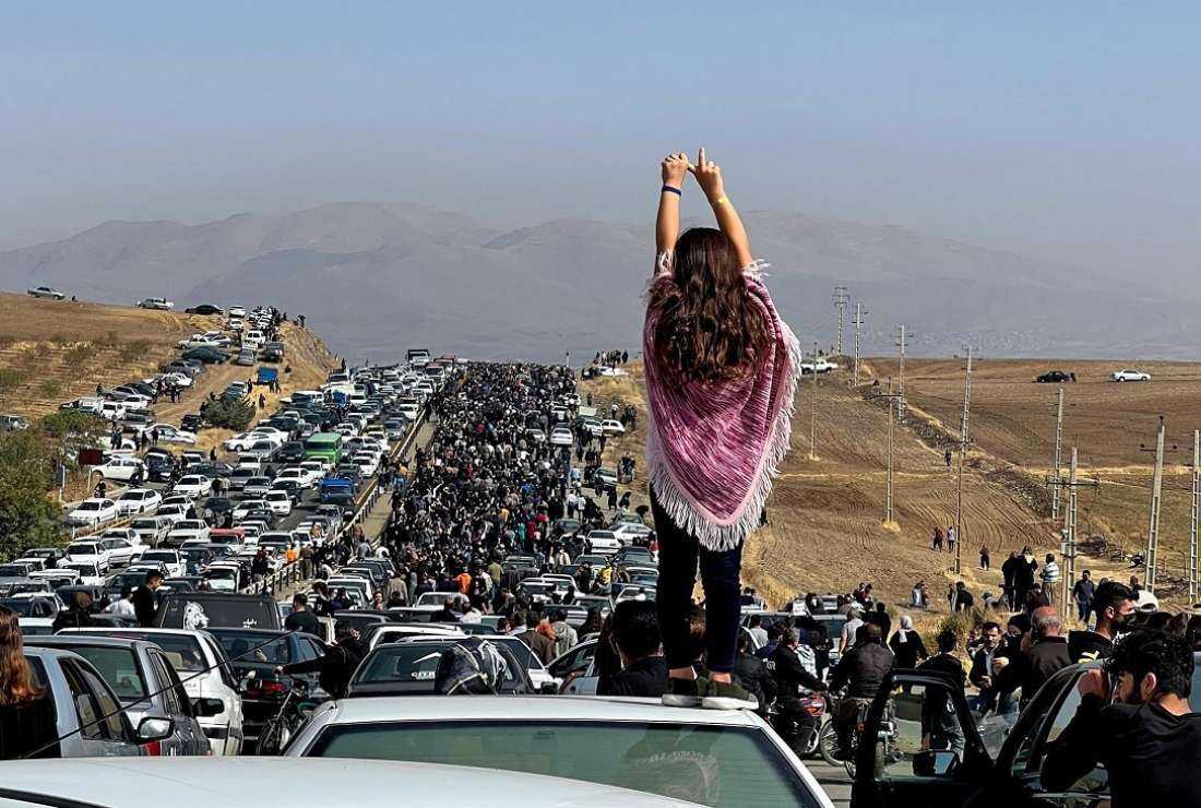This image posted on Twitter on Oct. 26 shows an unveiled woman standing on top of a vehicle as thousands make their way towards Aichi cemetery in Saqez, Mahsa Amini's hometown in Iran’s Kurdistan province to mark 40 days since her death, defying heightened security measures as part of a bloody crackdown on women-led protests