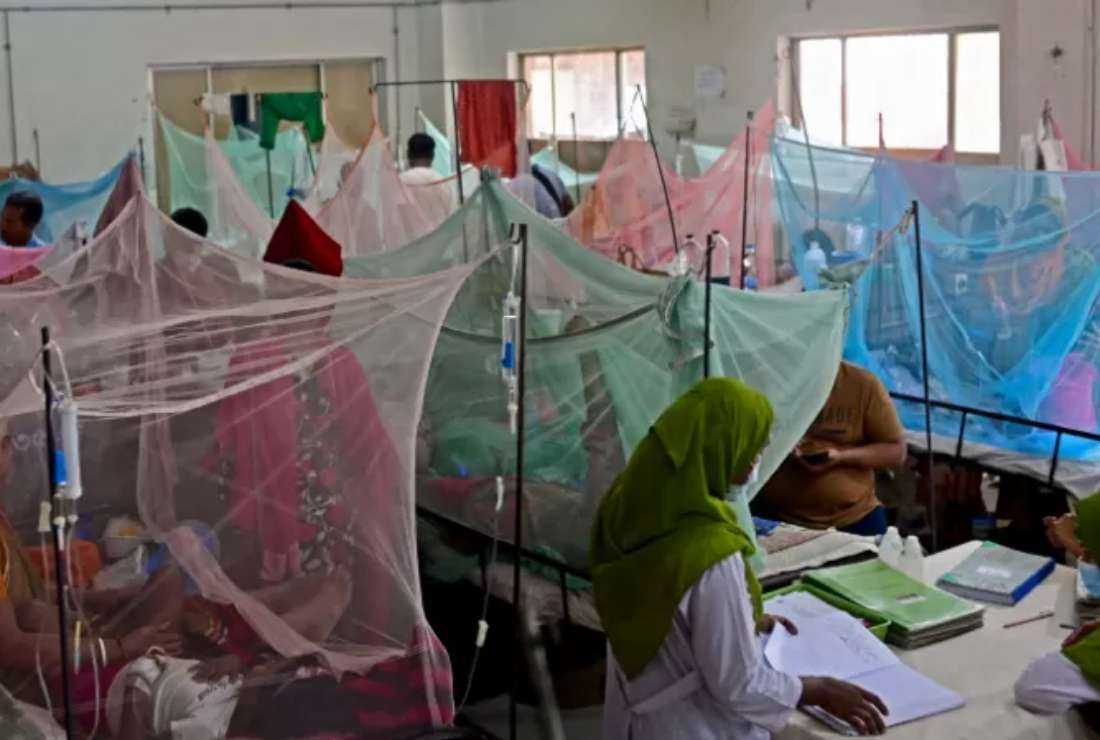 People comfort their children suffering from dengue fever at a government hospital in Dhaka on Oct. 19