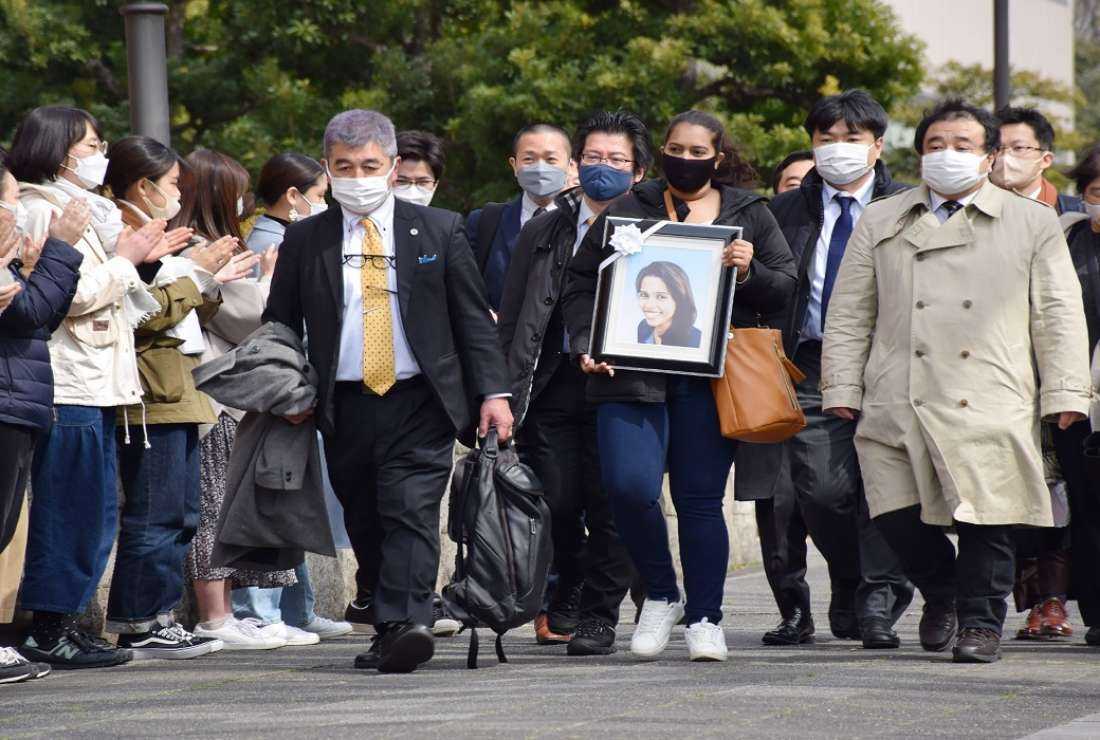The sister of a Sri Lankan woman, Wishma Sandamali, who died while in Japanese immigration detention, carries a picture of her late sister as she walks to the Nagoya district court on March 4 to file a lawsuit against the government of Japan