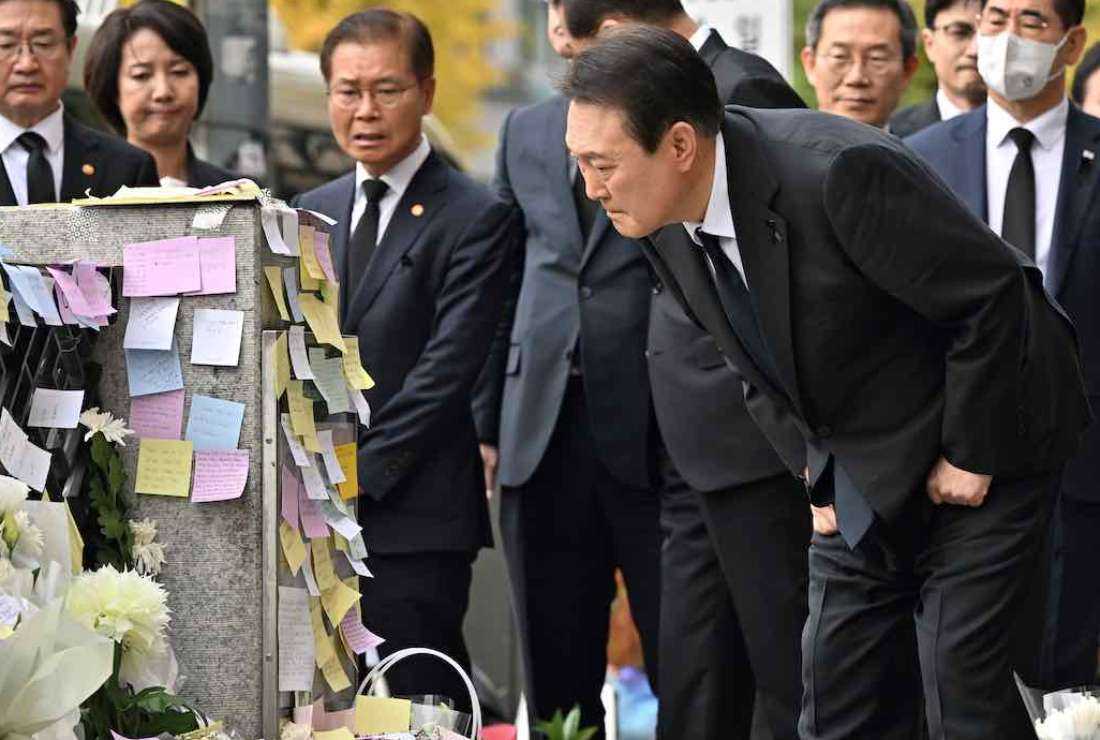 South Korean President Yoon Suk-yeol looks at messages of mourners at a makeshift memorial for the victims of the deadly Halloween crowd surge, outside a subway station in the district of Itaewon in Seoul on November 1, 2022