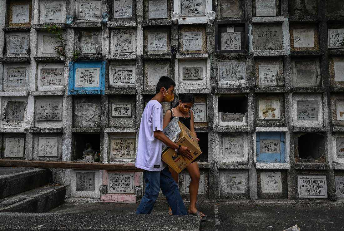 Relatives of a victim of the government's drug war carrying a box containing the remains after they were exhumed at Bagbag Cemetery in Novaliches, Metro Manila on June 10
