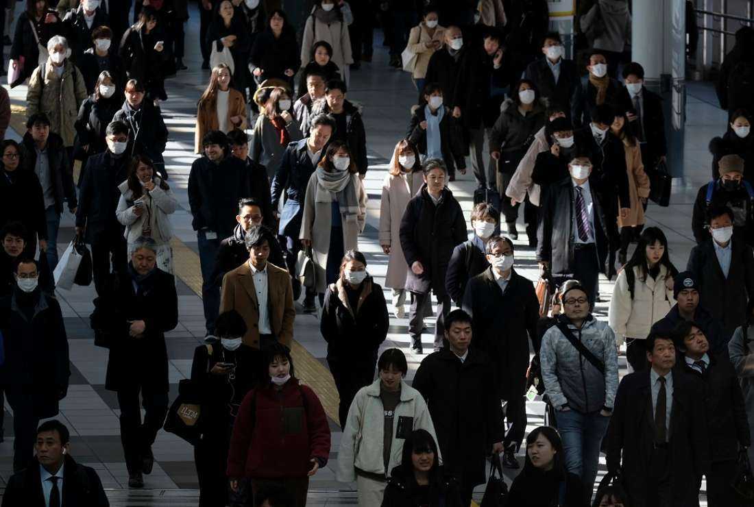 Commuters heading to work walk on a concourse at a railway terminal station in Tokyo on Jan. 31, 2020