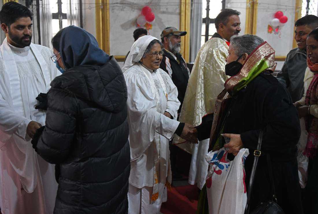 Indian Christian priests greet devotees after offering prayers during a service to mark Christmas at a church in Amritsar on Dec. 25, 2021
