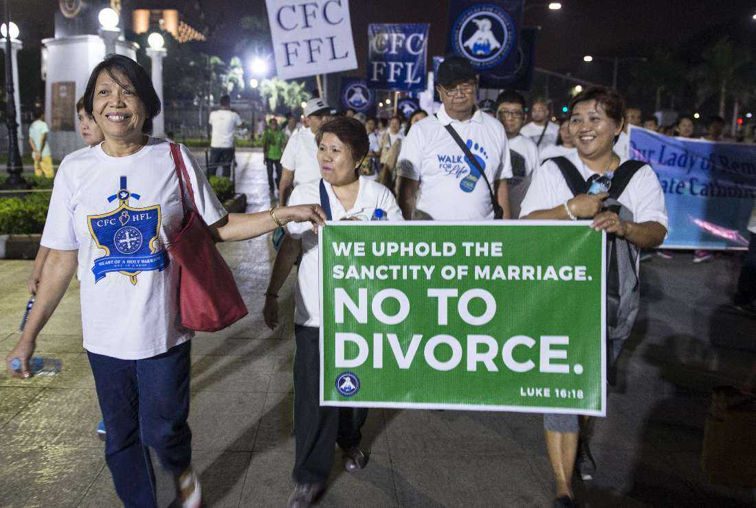 Philippine Catholic faithful holding a banner as they take part in a Walk for Life protest at a park in Manila on Feb. 24, 2018