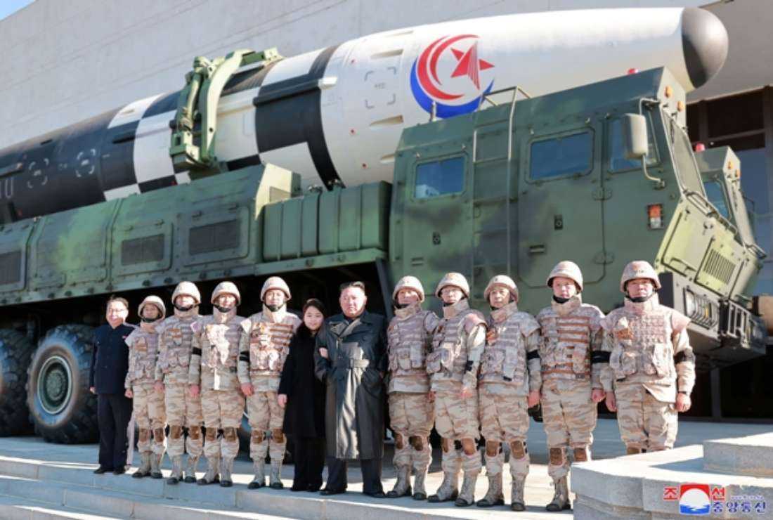 This undated picture released from North Korea's official Korean Central News Agency (KCNA) on Nov. 27 shows North Korea's leader Kim Jong Un (center right) and his daughter (center left) posing with soldiers who contributed to the test-firing of the new intercontinental ballistic missile (ICBM), at an unknown location in North Korea