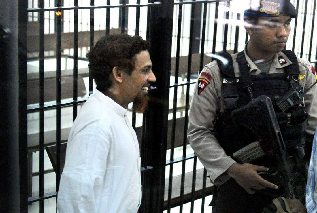 Terror suspect Umar Patek escorted by armed police steps out of a holding cell before attending his trial at a court in Jakarta on June 21, 2012