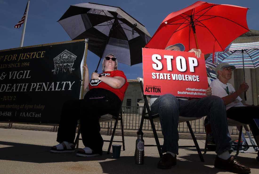 Alli Sullivan (left) of Portland, Oregon, participates in a vigil against the death penalty in front of the US Supreme Court on June 29, 2021, in Washington, DC