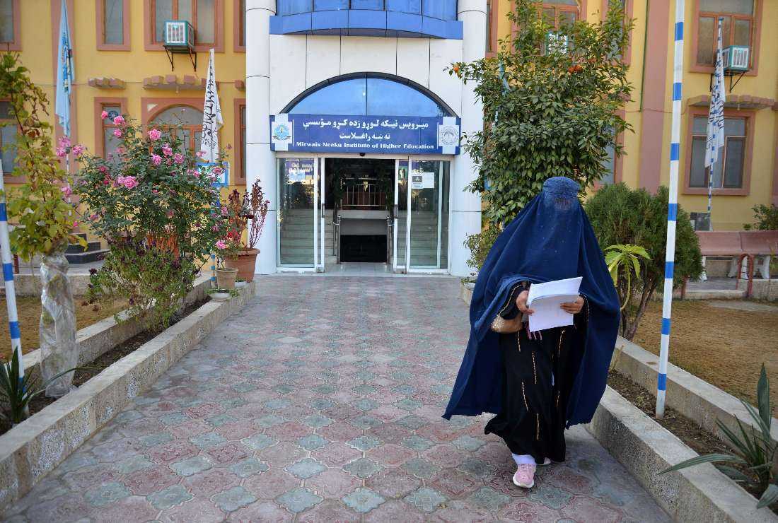 A female university student walks in front of a university in Kandahar Province on Dec. 21