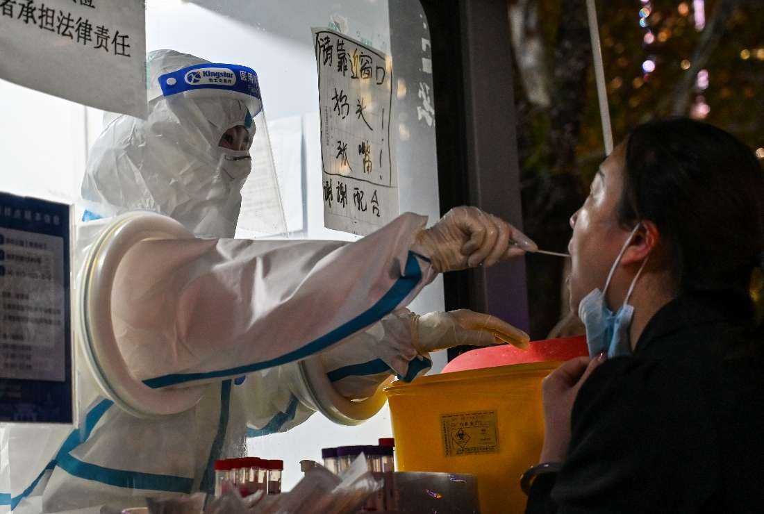 A Chinese health worker taking a swab sample from a woman to test for the Covid-19 coronavirus in the Jing'an district in Shanghai on Nov. 28