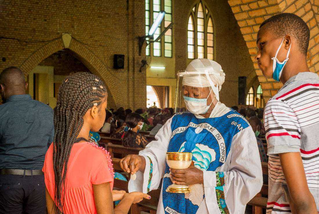 Catholics receive the Holy Communion during the service at the Notre Dame du Congo cathedral in Kinshasa on Aug. 16, 2020