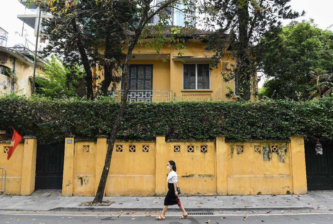 A Vietnamese woman walking past an old villa in Hanoi on Nov. 17