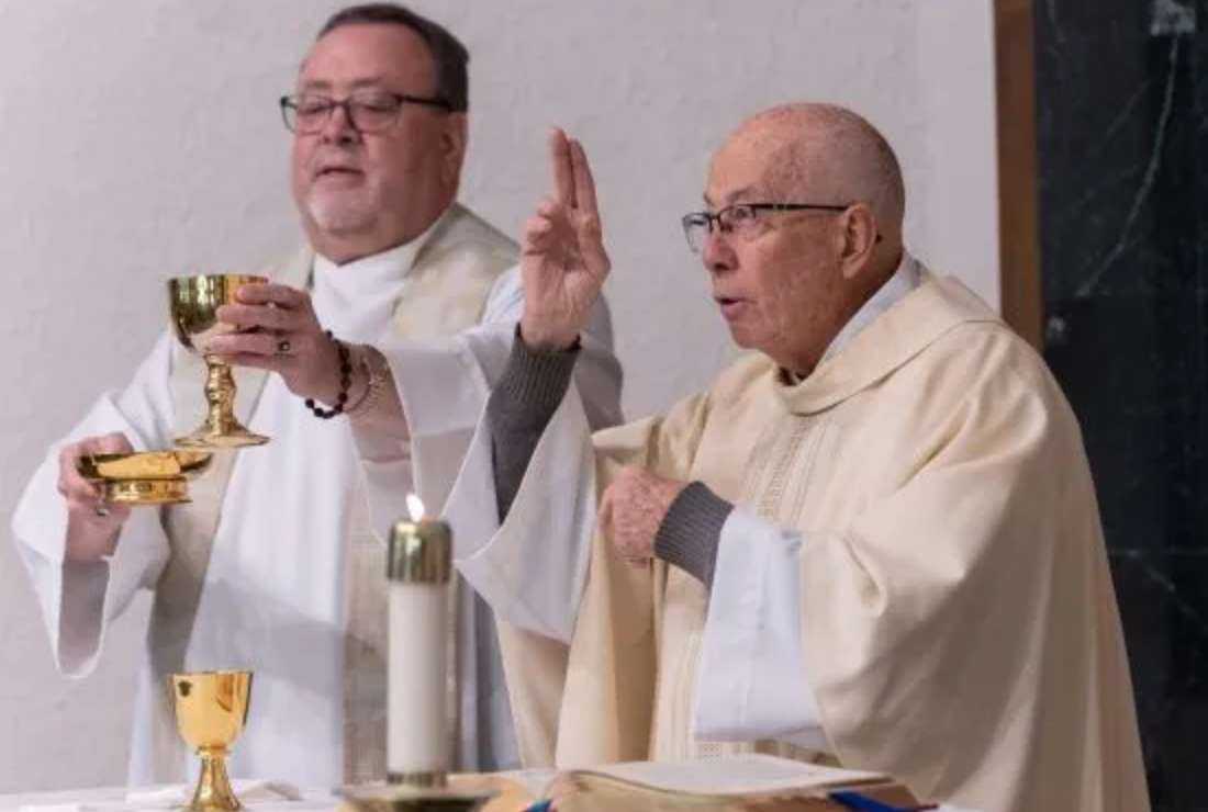 Father Tom Coughlin, the first deaf man ordained a priest in the U.S., prays the Eucharistic Prayer using sign language during Mass at Our Lady of Mount Carmel in Minneapolis Nov. 20. At left is Father Mike Krenik, the pastor of Our Lady of Mount Carmel, who is learning American Sign Language