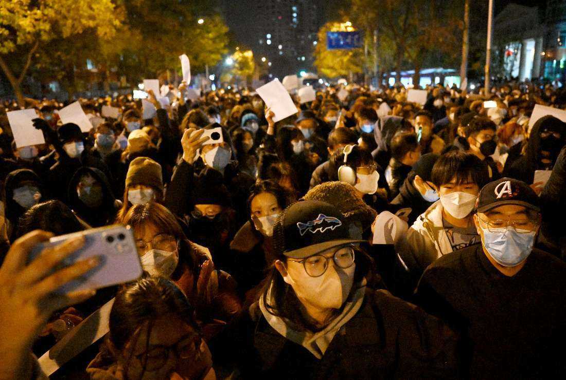 Protesters march along a street during a rally for the victims of a deadly fire as well as a protest against China's harsh Covid-19 restrictions in Beijing on Nov. 28