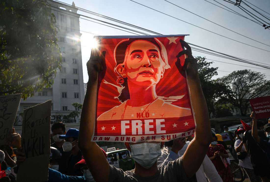 A protester holds up a poster featuring Aung San Suu Kyi during a demonstration against the military coup in front of the Central Bank of Myanmar in Yangon on Feb. 15, 2021
