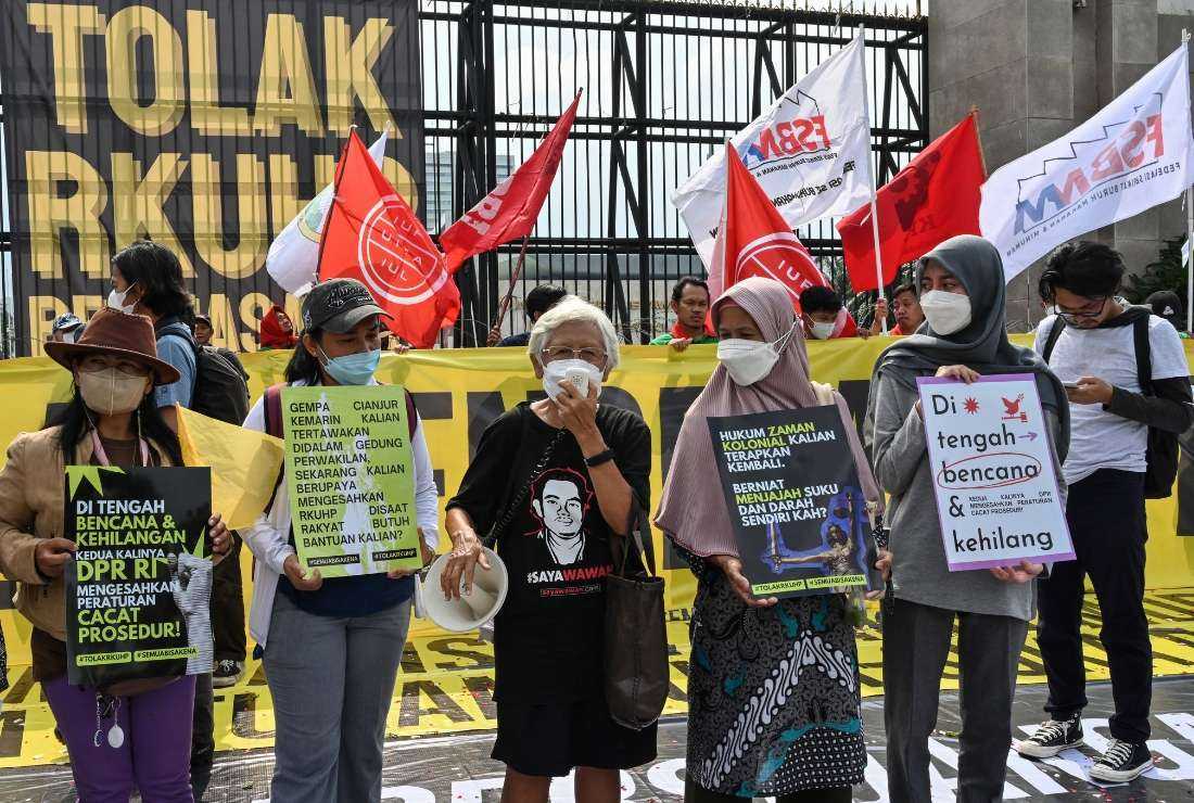 This picture taken on December 5, 2022 shows activists holding a protest against the new criminal code outside the parliament building in Jakarta. Indonesia's parliament approved on December 6 legislation that would outlaw pre-marital sex while making other sweeping changes to the criminal code -- a move critics deemed as a setback to the country's freedoms