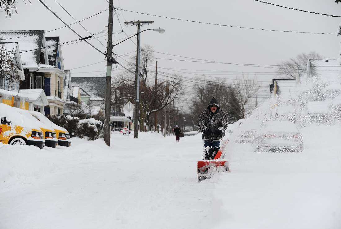 Chris Graziano clears heavy snow along Richfield Street in Buffalo, New York on Dec. 27