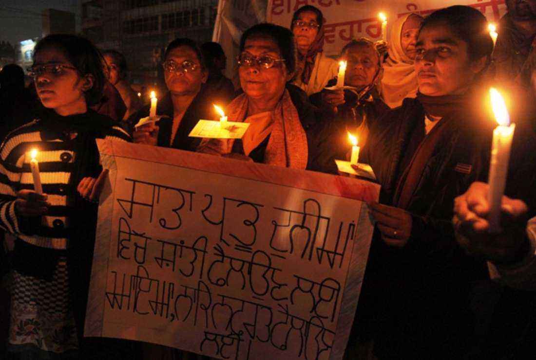Indian Christian devotees hold candles and placards as they pose for a photograph during a demonstration against a suspected attack on a church in Amritsar on Dec 2, 2014