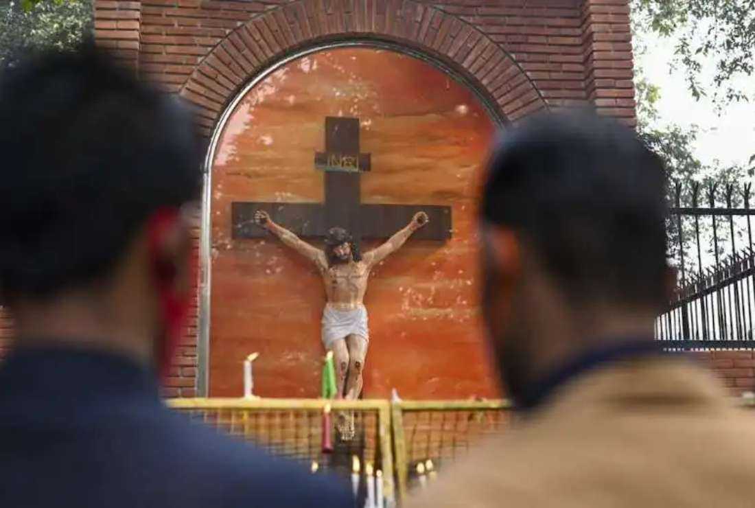 Indian Christians pray behind a police barricade outside Sacred Heart Cathedral, closed to the general public due to the Covid-19 pandemic, during Christmas celebrations in New Delhi on Dec. 25, 2021