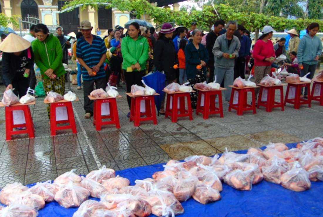 Vietnamese people are given pork and sticky rice at Dien Loc church on Jan 15