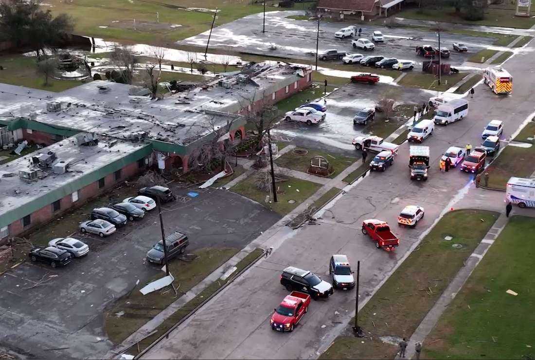 Emergency services and security personnel gather in front of a building that was devastated in the recent tornado that hit Pasadena, Texas on Jan. 24