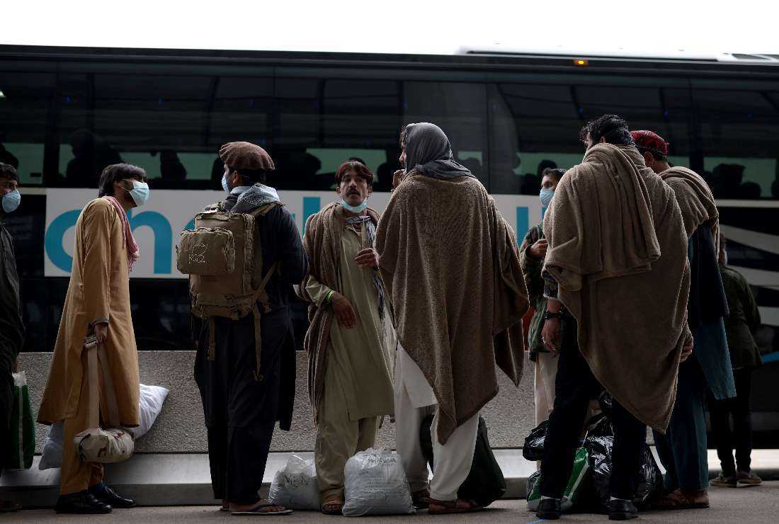 Refugees board a bus at Dulles International Airport that will take them to a refugee processing center after being evacuated from Kabul following the Taliban takeover of Afghanistan, in Dulles, Virginia on Aug. 31, 2021
