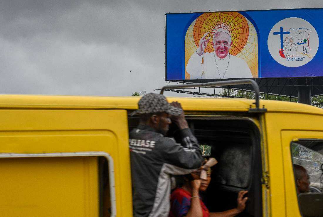 A billboard shows an image of Pope Francis as passengers travel on a minibus in Kinshasa on Jan. 22