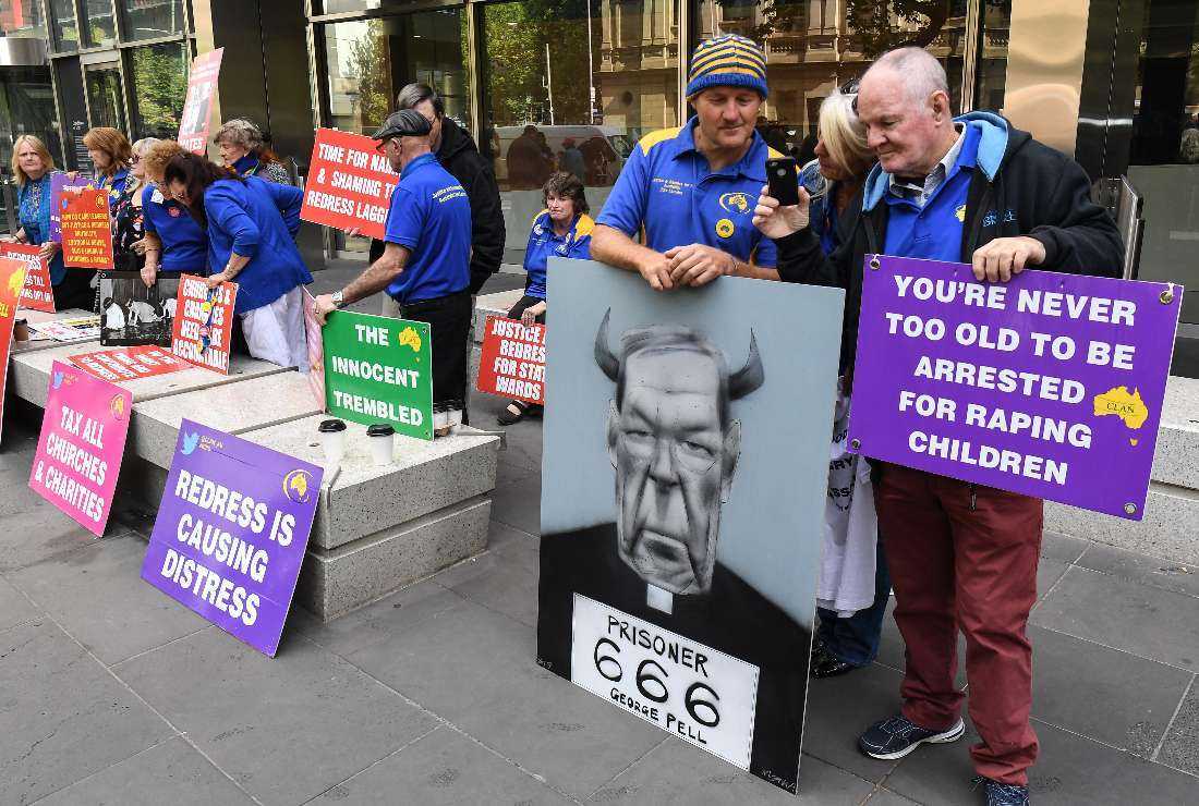 Protesters hold placards outside the County Court to hear the sentencing of Cardinal George Pell in Melbourne on March 13, 2019. Disgraced Australian Cardinal George Pell was sentenced to six years in jail for child sex crimes in a Melbourne court with a minimum period of three years and eight months to be served