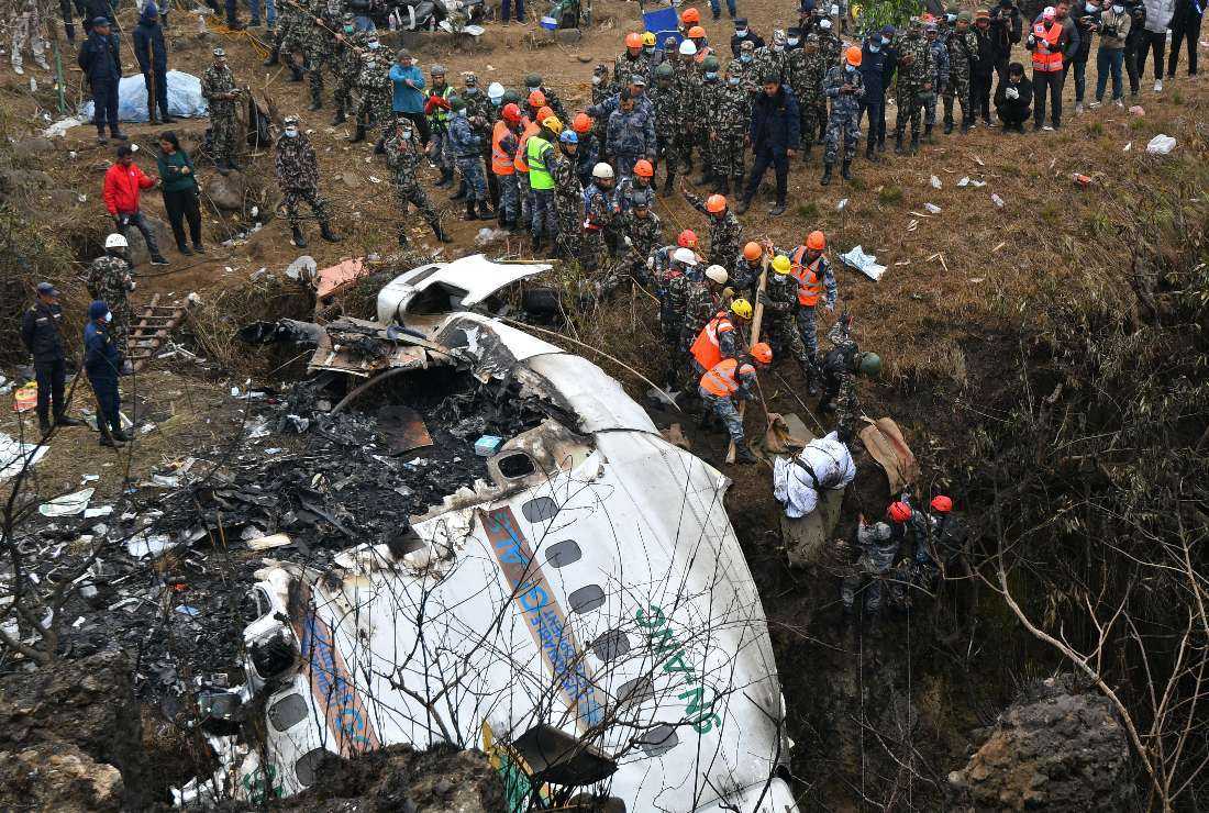 Rescuers pull the body of a victim who died in a Yeti Airlines plane crash in Pokhara on Jan. 16