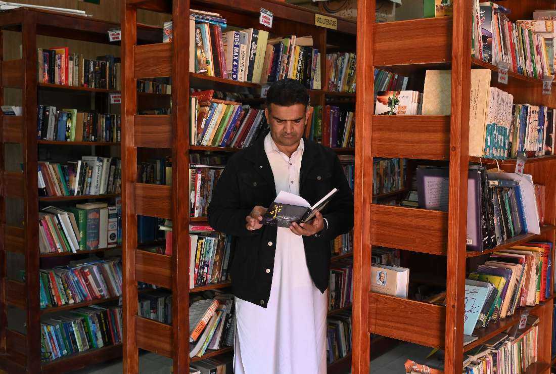 In this photograph taken on Jan. 4, a former arms dealer and founder of Darra Adam Khel Library, Raj Muhammad looks at a book inside the library in Darra Adamkhel town, some 35 kilometres (20 miles) south of Peshawar