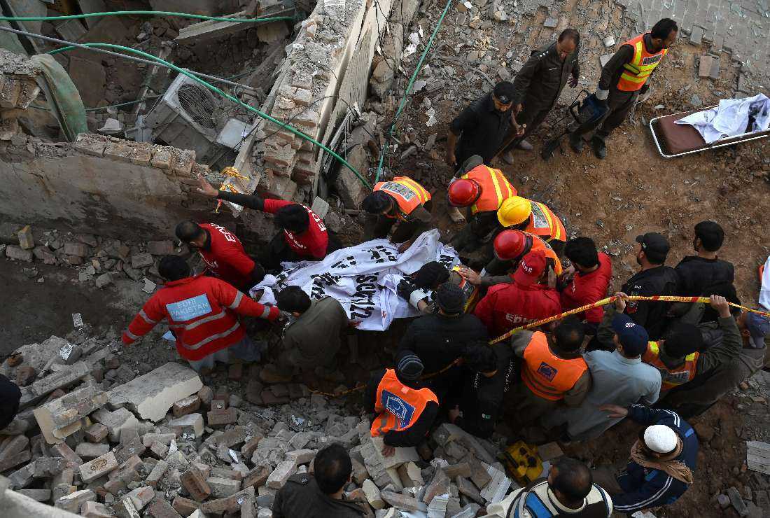 Rescue workers carry the remains of the blast victims from the debris of a damaged mosque after a blast inside the police headquarters in Peshawar on Jan. 30