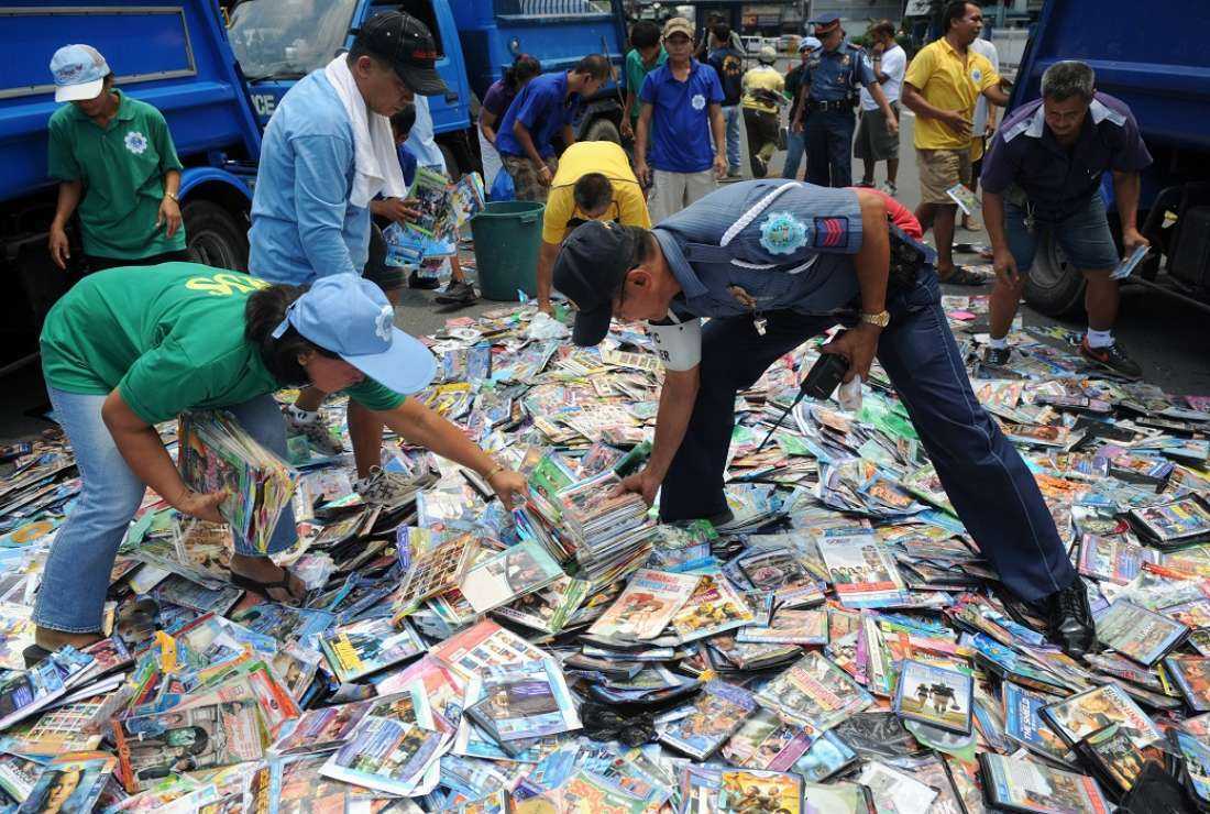 A Filipino policeman supervises the removal of destroyed fake DVDs during a ceremonial destruction of counterfeit and pirated goods at the National Police headquarters in Manila in this June 23, 2010 file photo