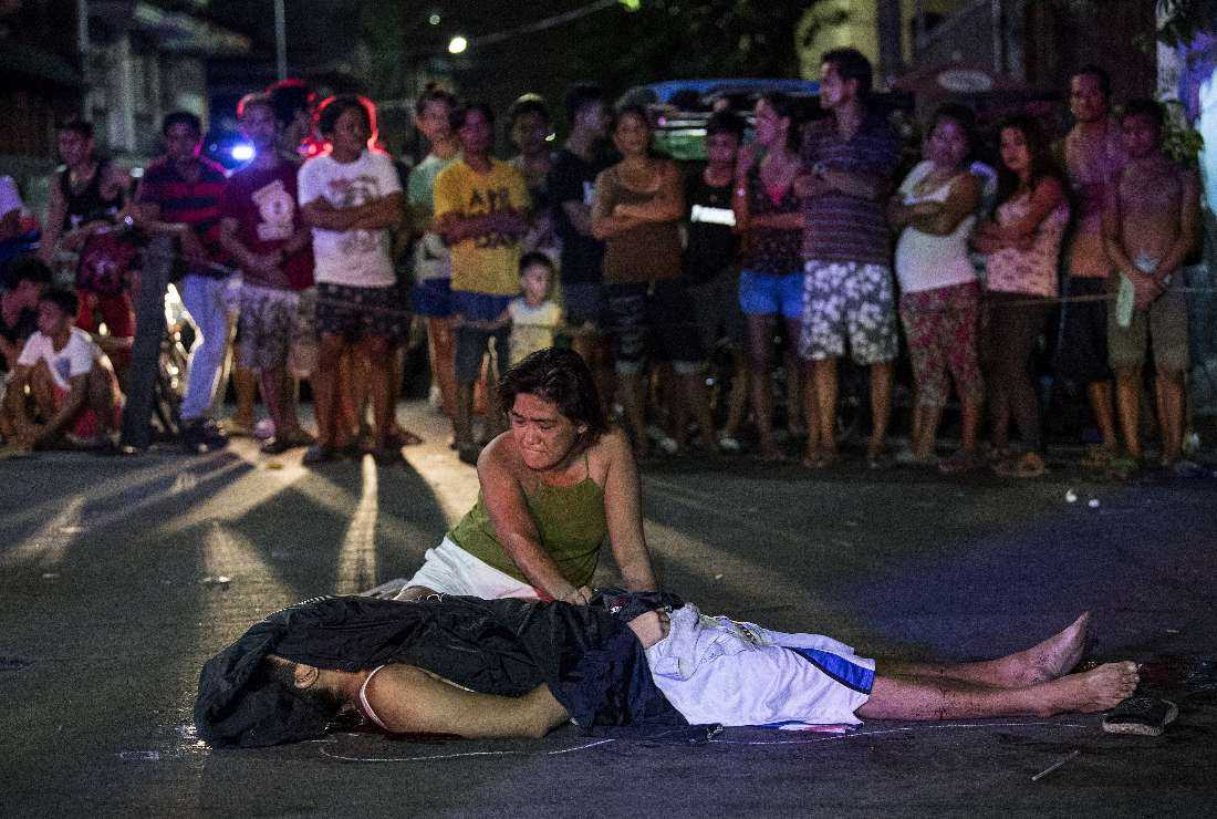 In this file photo taken on Oct. 3, 2017, Nanette Castillo grieves next to the dead body of her son Aldrin, an alleged drug user killed by unidentified assailants, in Manila